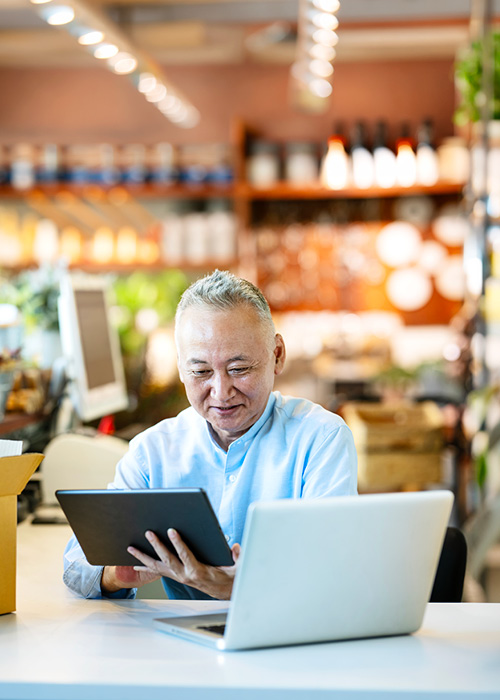 man looking at tablet and laptop