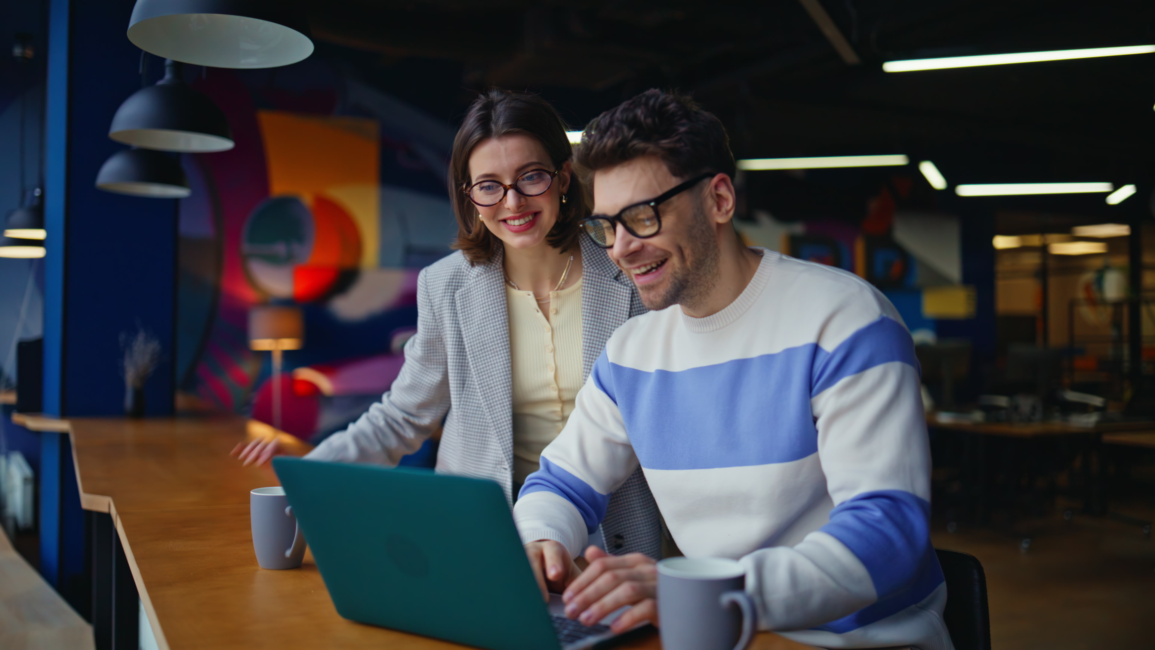 people smiling using a laptop